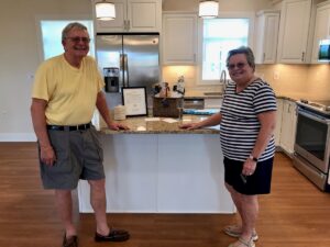 Residents stand in the stylish kitchen of a new senior living cottage at The Culpeper.